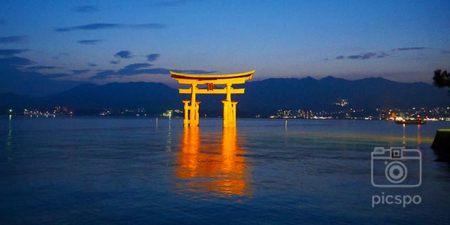 広島県宮島市の厳島神社の夜の提灯と松の木が並ぶ大きな鳥居写真素材2232123359Shutterstock