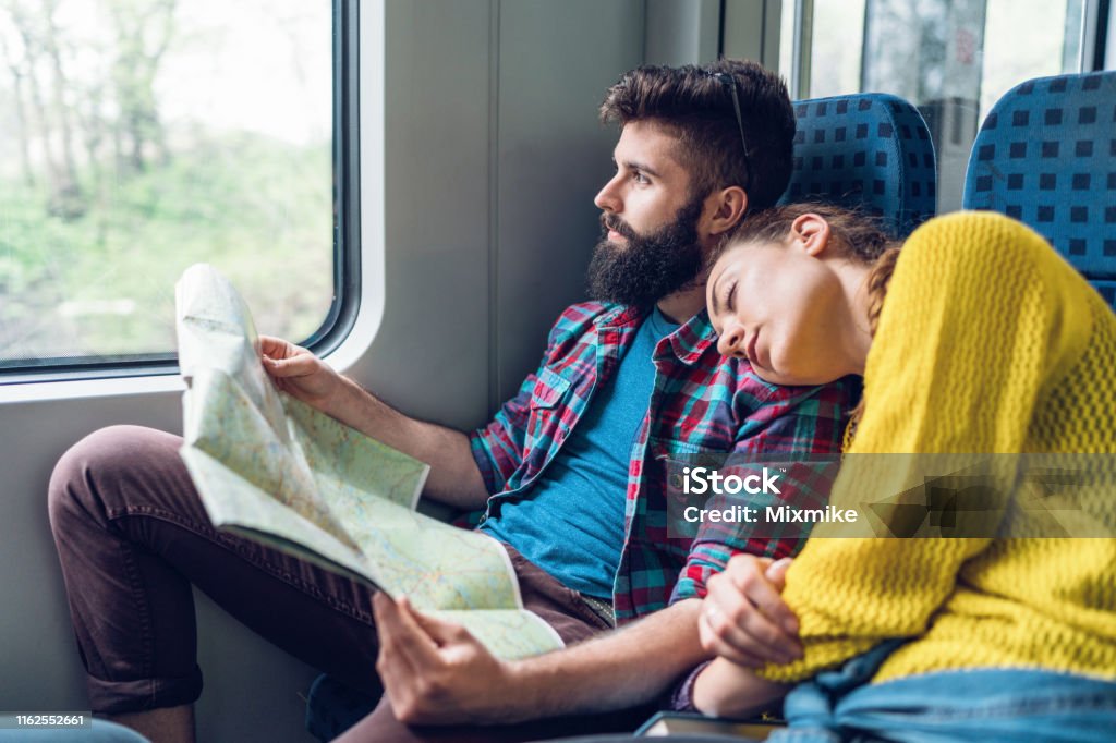 リラックスしたカップル電車で旅行 - 列車のストックフォトや画像を多数ご用意 - 列車,